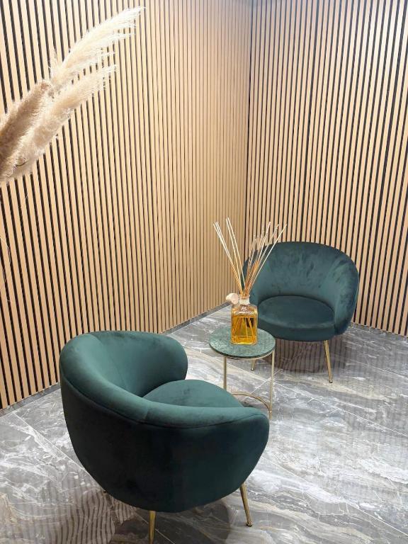 two blue chairs and a table in a room at Aura Suite in Parma