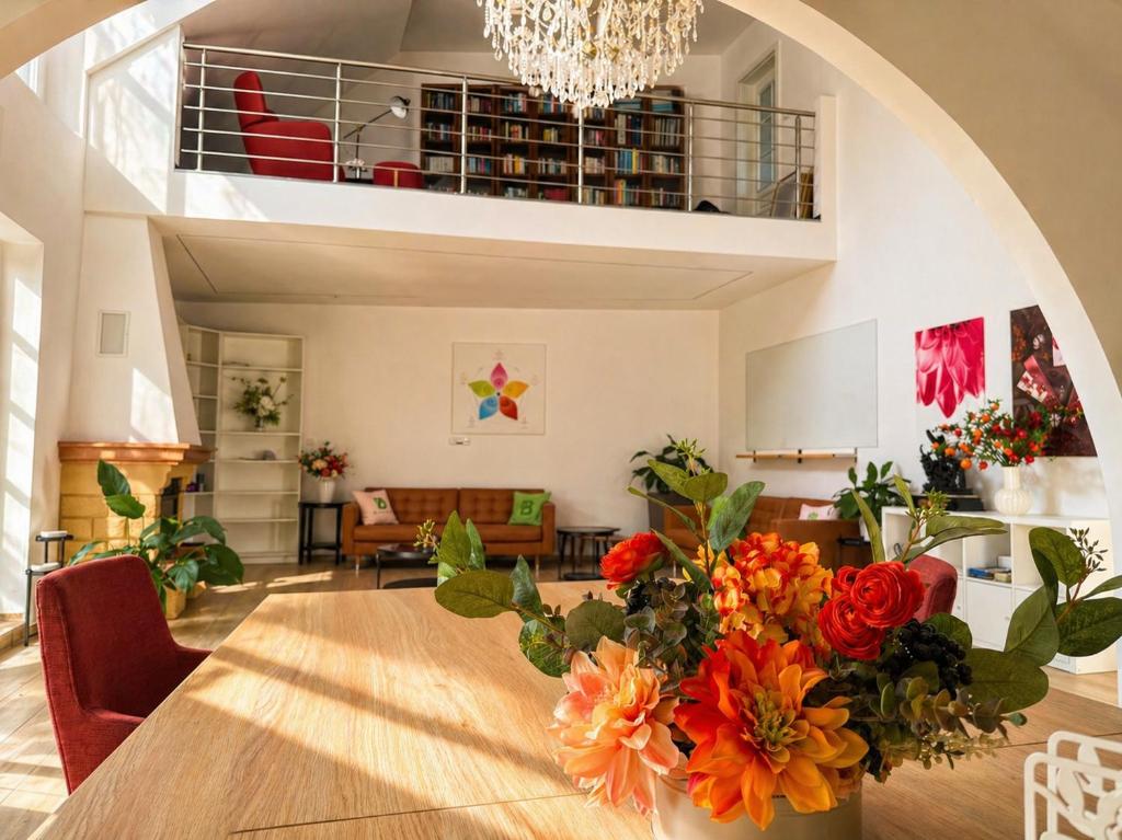 ein Wohnzimmer mit einem Tisch, auf dem Blumen stehen in der Unterkunft Biomade in Prag