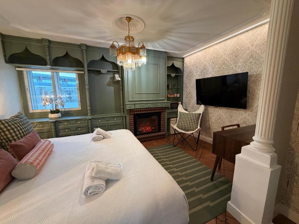 a bedroom with a bed with a fireplace and a tv at The Suite Collection in Fuengirola