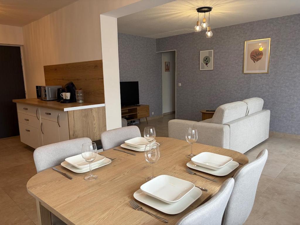 a dining room table with chairs and wine glasses at L'essentiel in Hambach