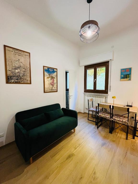 a living room with a green couch and a table at Alpine Cozy Studio Limone Piemonte in Limone Piemonte