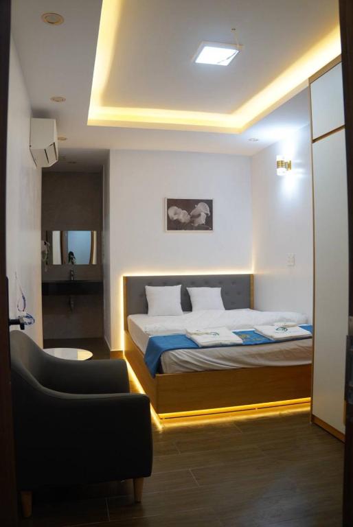 a bedroom with a bed and a chair in a room at Khách sạn Vin Hồ in Thế Rương