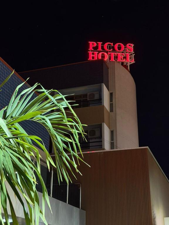 a red neon sign on top of a building at Picos Hotel in Picos