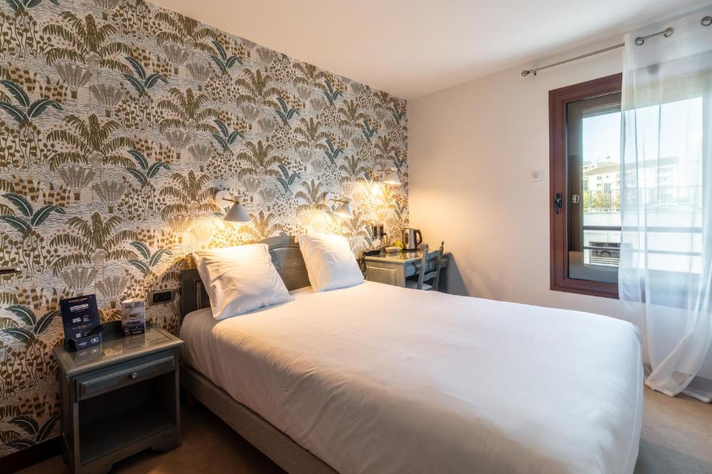 ein Schlafzimmer mit einem großen Bett und einem Fenster in der Unterkunft Contact Hôtel Des Deux Moulins Limoges, Proche de la gare in Limoges