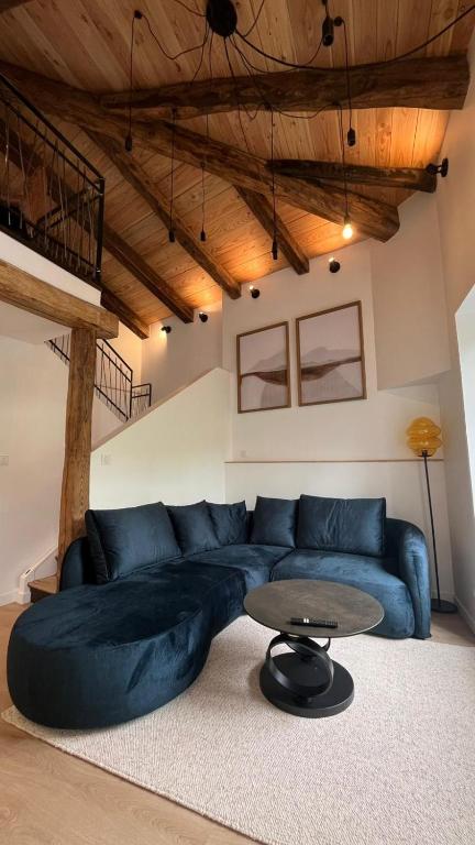 a living room with a blue couch and a table at Les Appartements de Millau in Millau