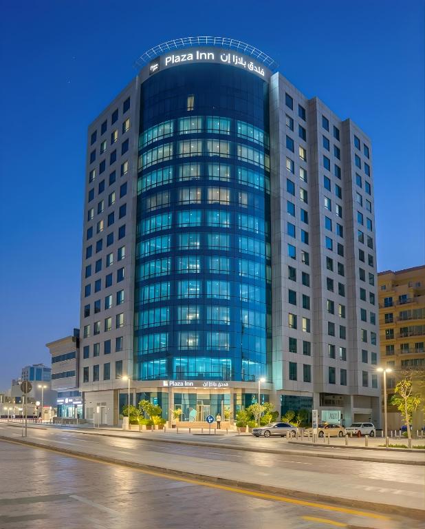 a large building with a sign on top of it at Plazza In Hotel in Doha