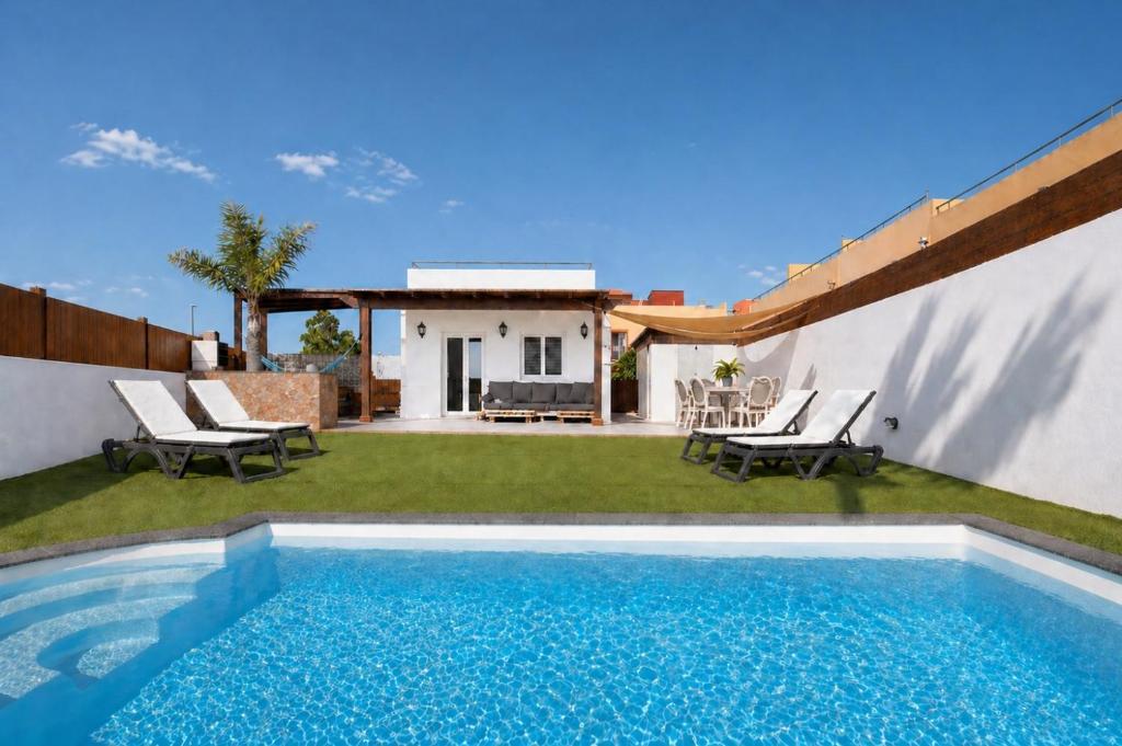 a villa with a swimming pool and a house at Villa del Relax in Corralejo