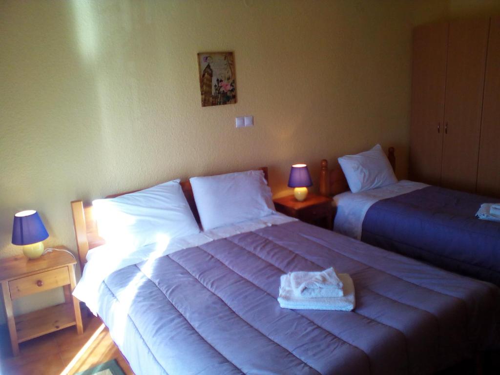 コニツァにあるHotel Aoosのベッドルーム(ベッド2台、ランプ2つ、トゥカーン付)