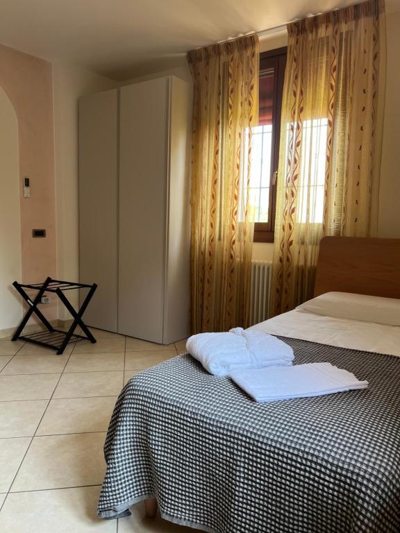 a bedroom with a bed with two towels on it at Agri Alloggio Poggiolina in Bagnara di Romagna