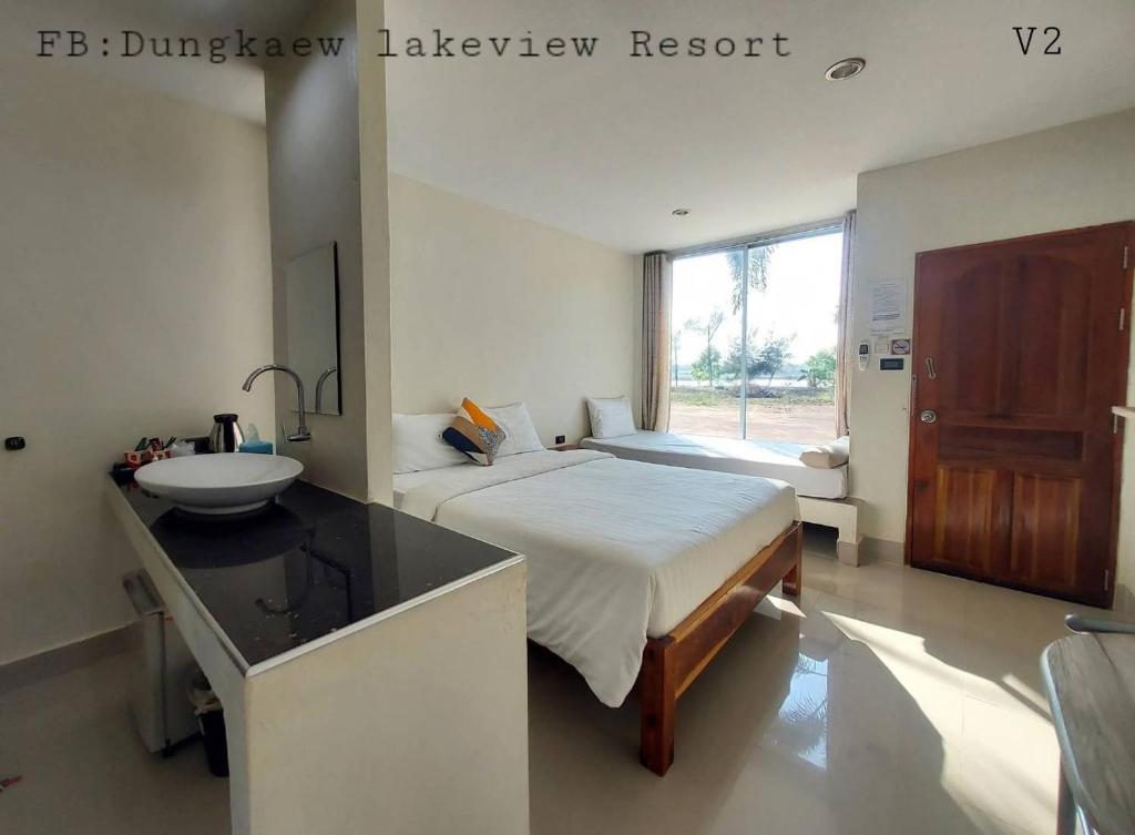 a bathroom with a bed and a sink in a room at Dungkaew lakeview resort in Amphoe Ban Dung