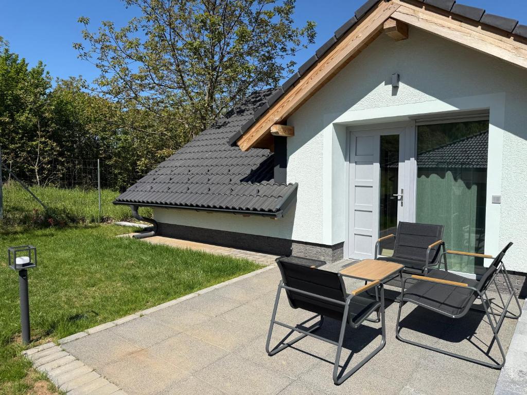 a house with two chairs and a table in front of it at Völgyzugoly Apartman in Kőszeg