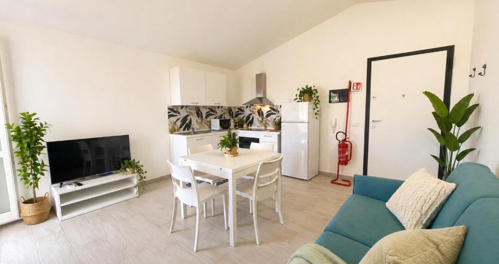 a living room with a table and a blue couch at Dimora Mary - Vicino al mare in La Maddalena