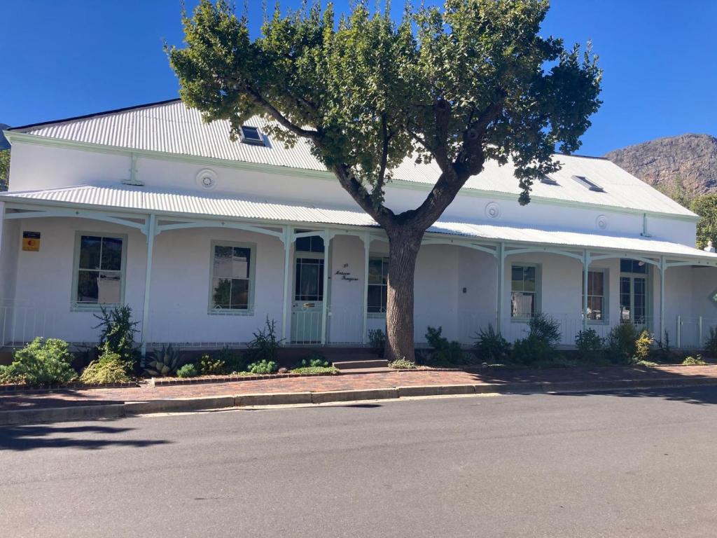 a white house with a tree in front of it at Maison Fougere in Franschhoek