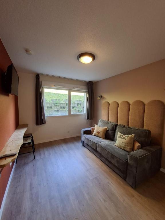 a living room with a couch and a window at Le 540 - Annecy - Parking in Annecy