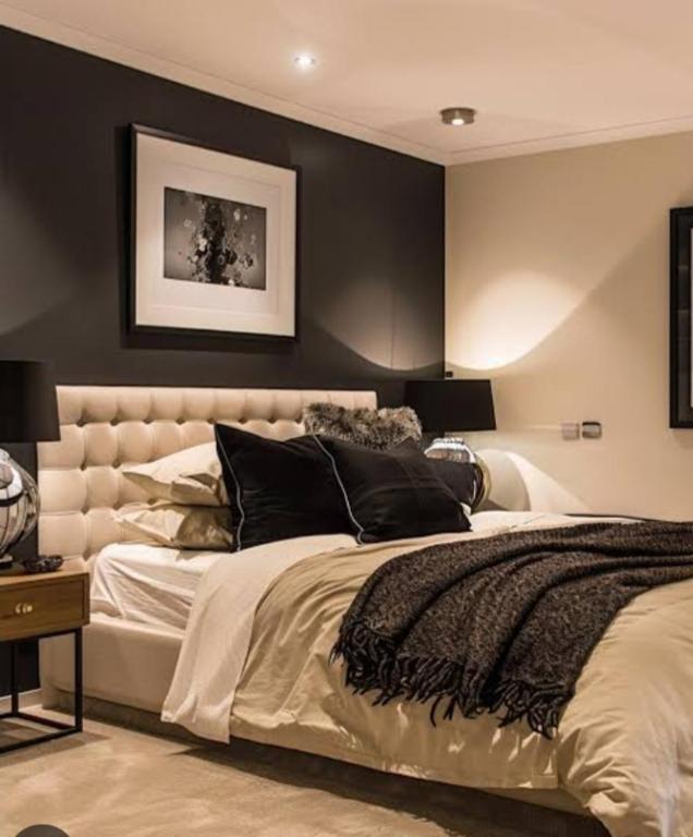 a bedroom with a large bed with black walls at Team Sek Guest Studio in Mahikeng