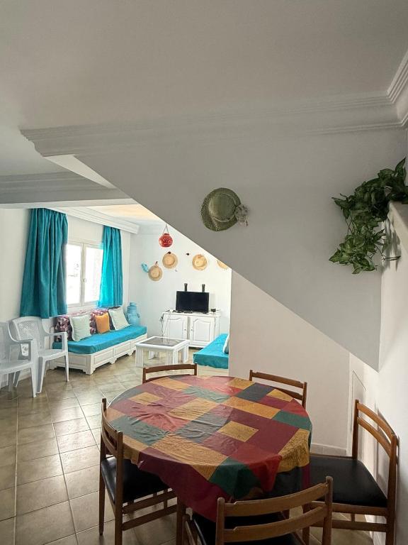 a dining room with a table and a living room at Duplex Marina Monastir in Monastir