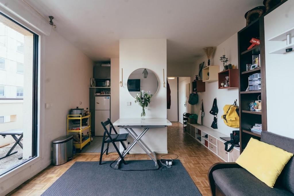 a living room with a table and a couch at Bel appartement balcon - 2 personnes in Malakoff