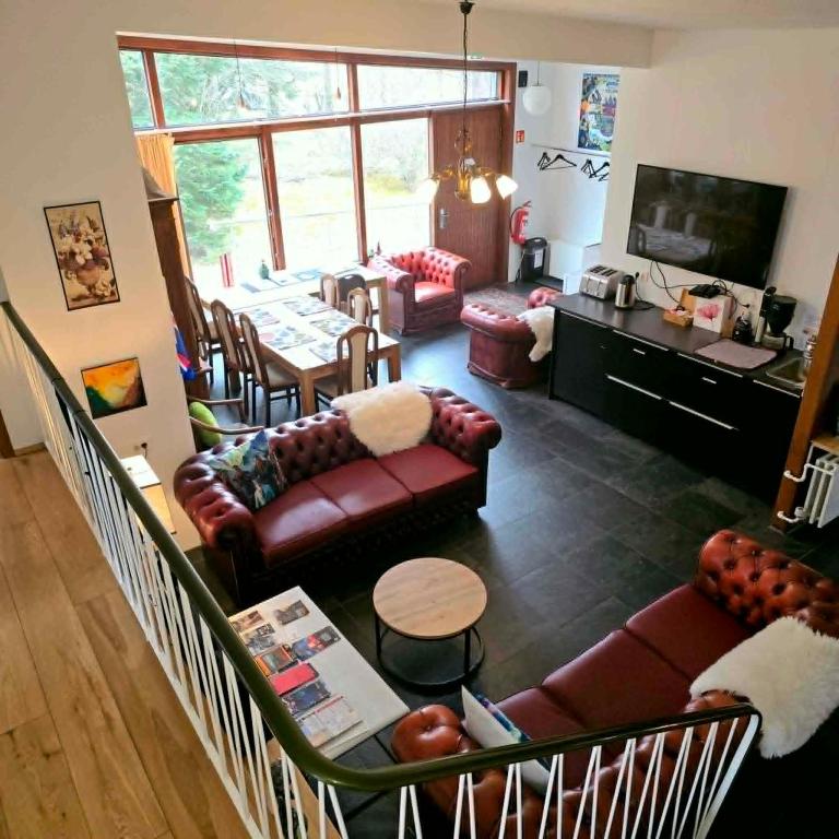 a living room with couches and a dining room at Spói Guesthouse in Hvolsvöllur