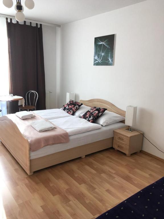 a bedroom with a large bed and a wooden floor at Penzión Kýčera in Oščadnica