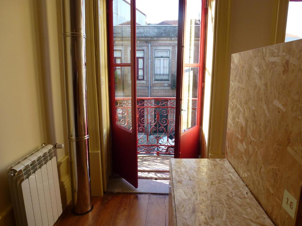 een open deur naar een kamer met een balkon bij Canvas Atelier Hostel in Porto