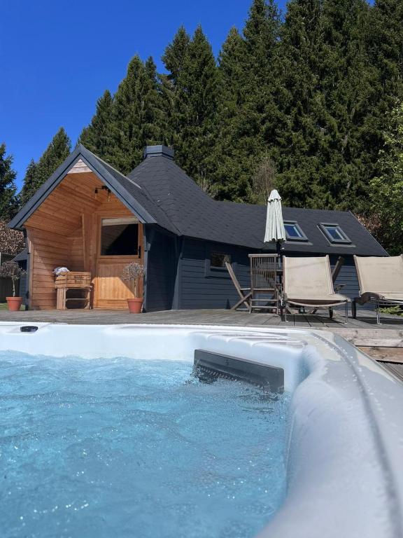 a house with a swimming pool and an umbrella at Hatton Lodge in Dunkeld