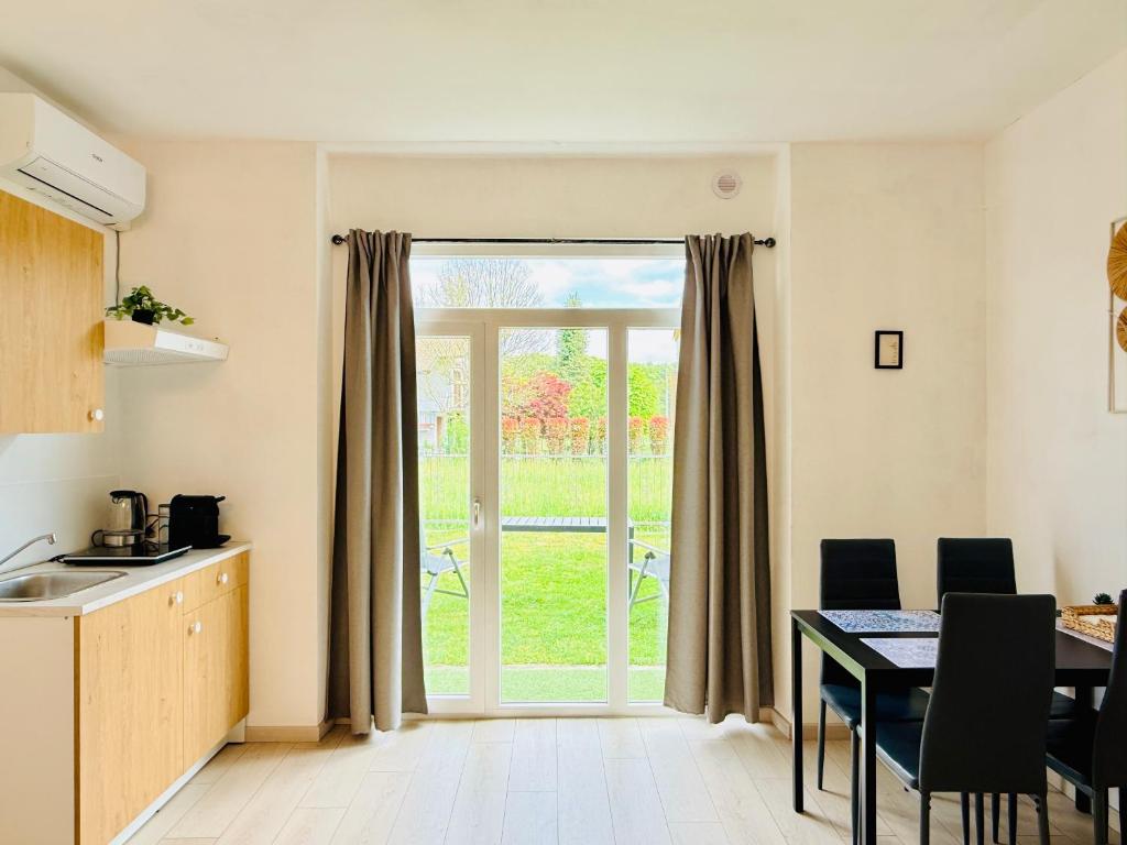 a kitchen with a table and a large window at Casa Buda 2BR Apartment-Lakes Malpensa MXP 24h Check-in Parking in Sesto Calende