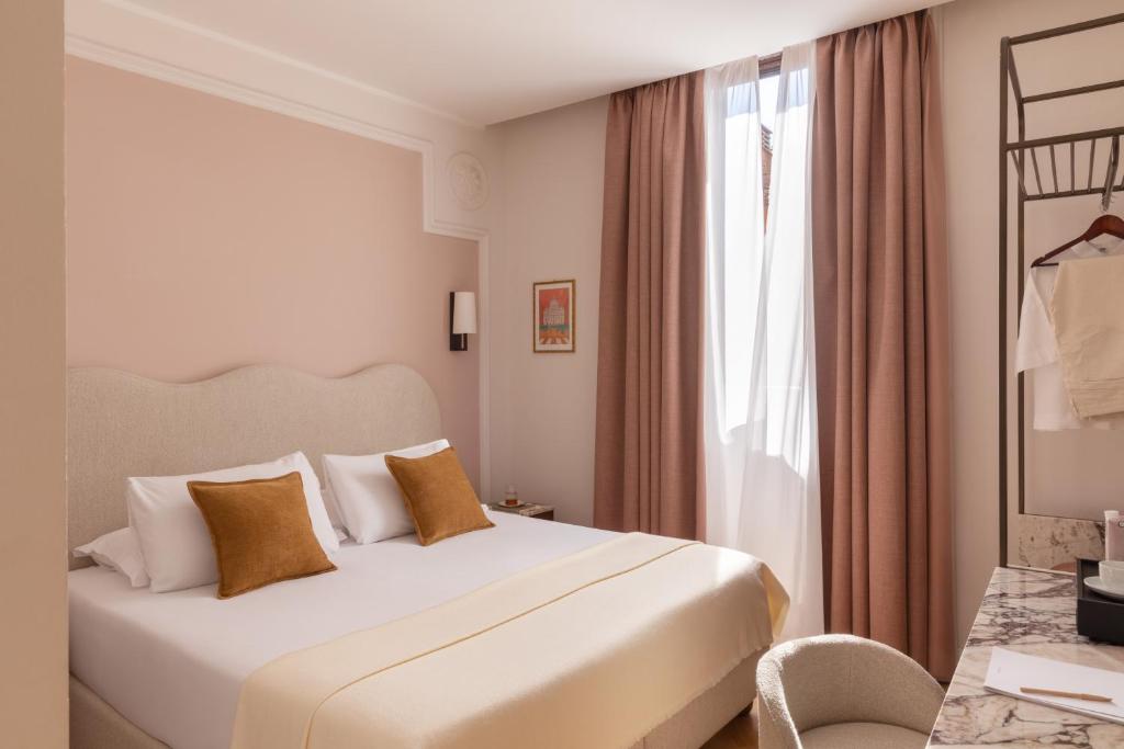 a bedroom with a white bed and a window at Hotel Fori Imperiali in Rome