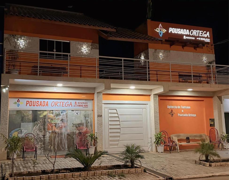 a building with a balcony and a parking garage at POUSADA ORTEGA in Bodoquena