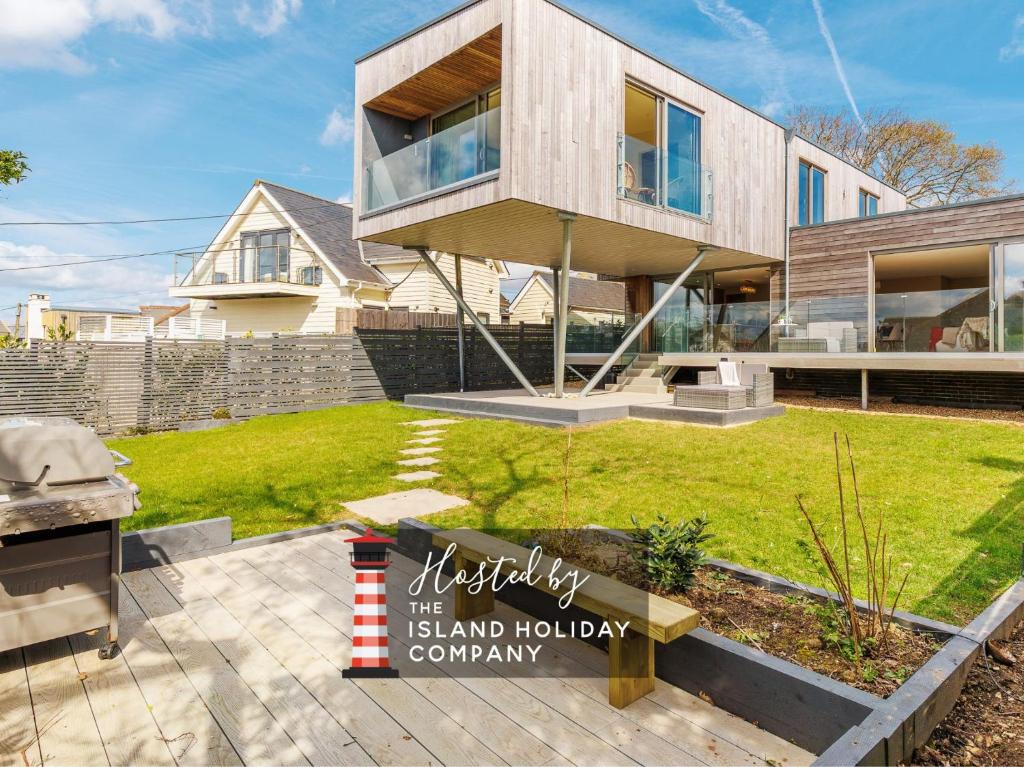 a house with a sign in front of it at Rena's Retreat - Luxury Architectural Eco Home with hot tub a short walk from Gurnard in Cowes - Perfect Lux Stay for Sailers Couples and Older Families in Gurnard