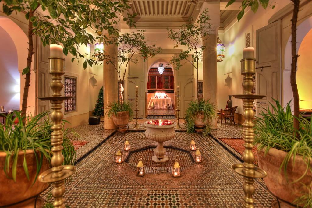 eine Lobby mit einem Brunnen in der Mitte eines Zimmers mit Pflanzen in der Unterkunft Dar Lalla F'dila in Marrakesch