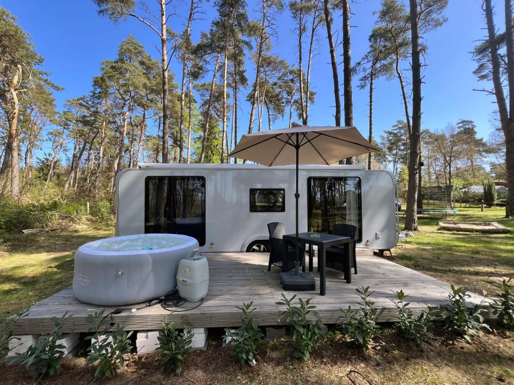 a bath tub sitting on a wooden deck next to a rv at Ferienhäuser Insel Usedom - Luxuswohnwagen Doppeltür mit Whirlpool in Lütow