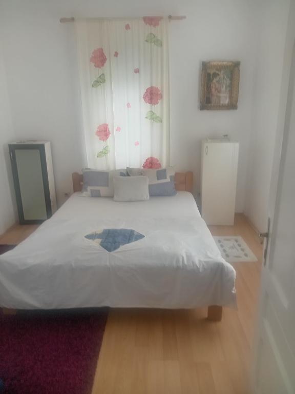 a bedroom with a large white bed with a window at Palamar in Kuršumlija