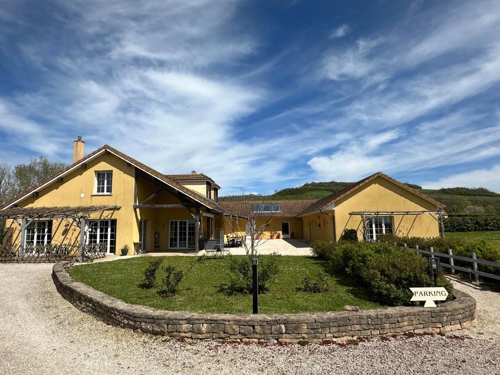 a large yellow house with a bench in front of it at Le Clos des 4 Saisons in La Rochepot