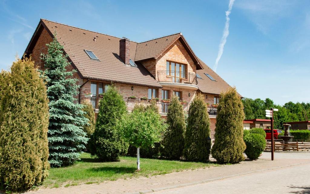 a house with trees and bushes in front of it at Podkowa in Police