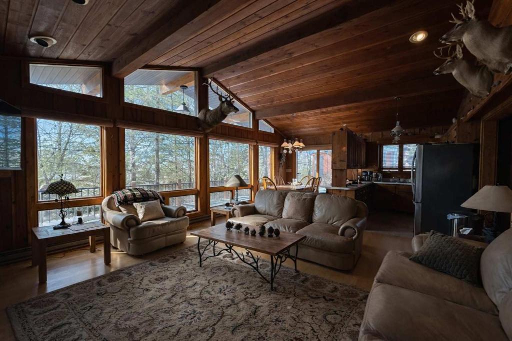 a living room with couches and a table at Stack's Back Bay Retreat in Minocqua