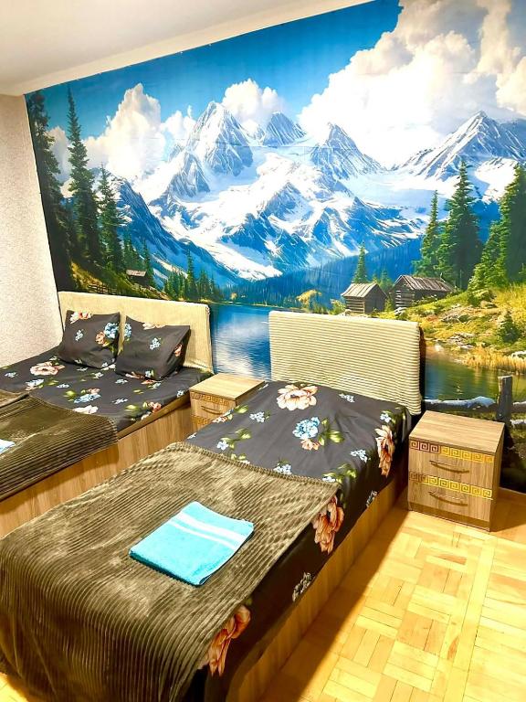 two beds in a room with a mountain mural at Budget Home in Kutaisi