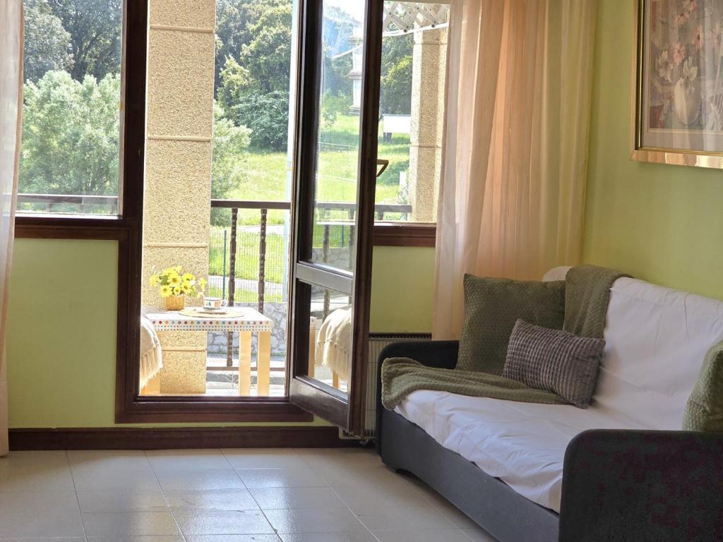 a living room with a couch in front of a window at Apartamento Candela 6904 in Noja
