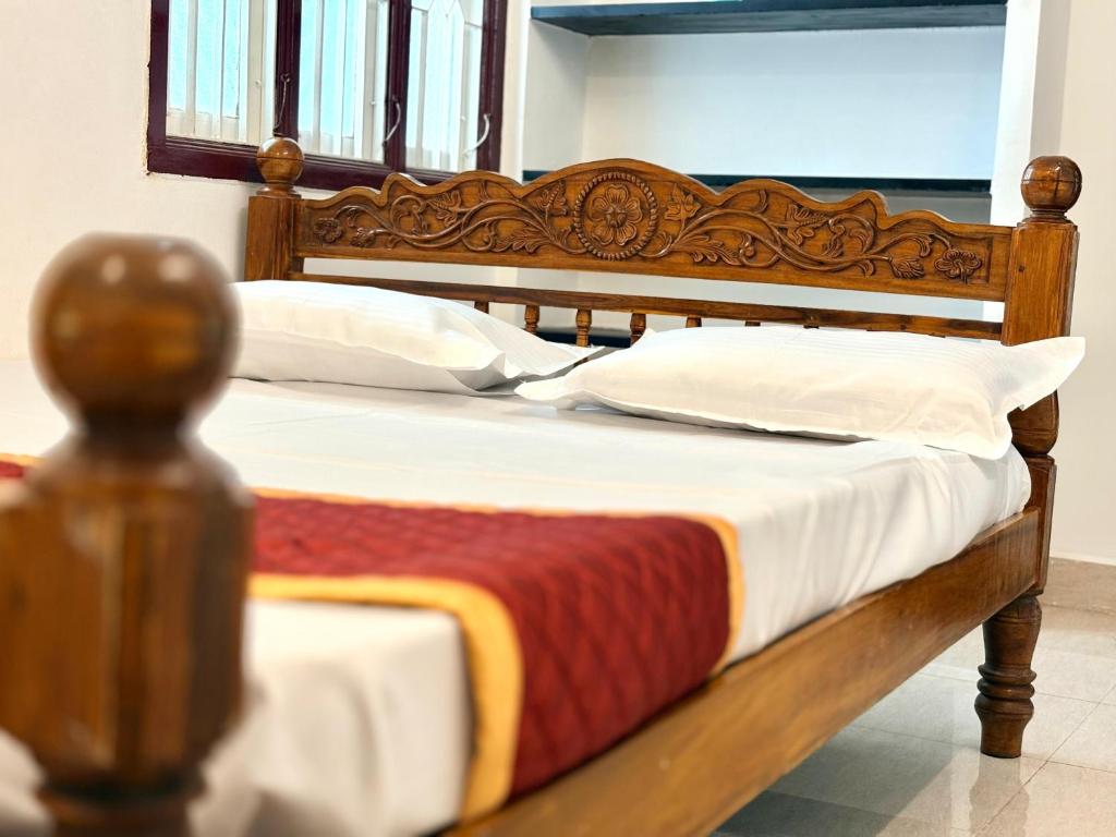 a bed with a wooden headboard and pillows at Neon Villa in Pondicherry