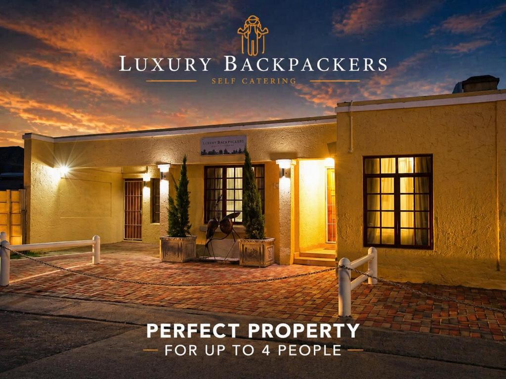 a building with a sign that reads perfect property for up to people at Luxury Backpackers in Port Elizabeth