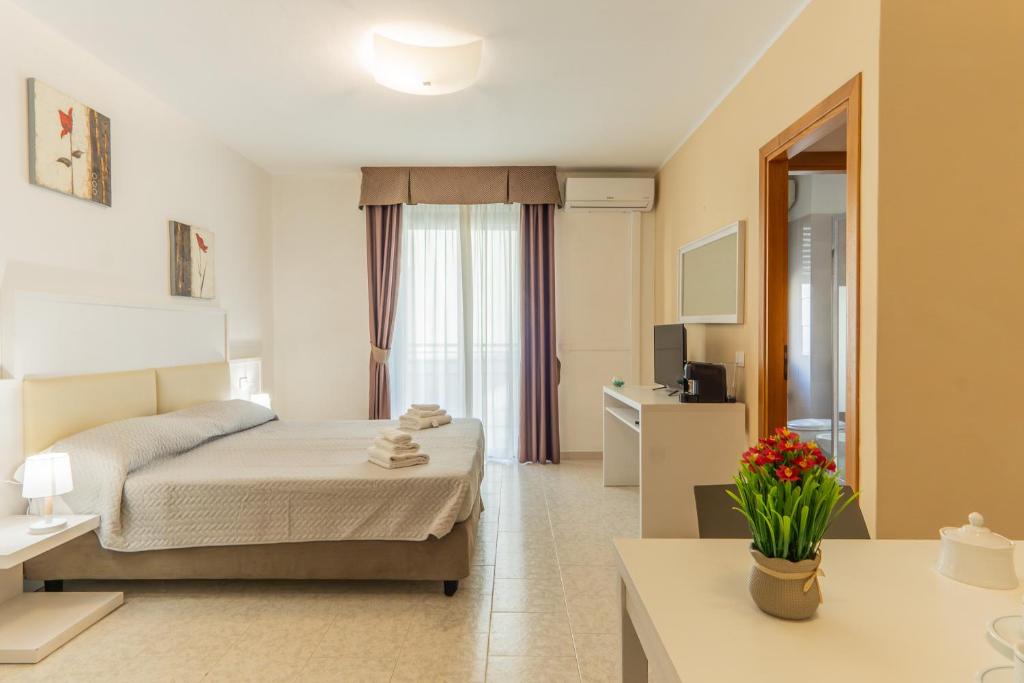 a hotel room with a bed and a table at Rina Sea Apartments in Alghero