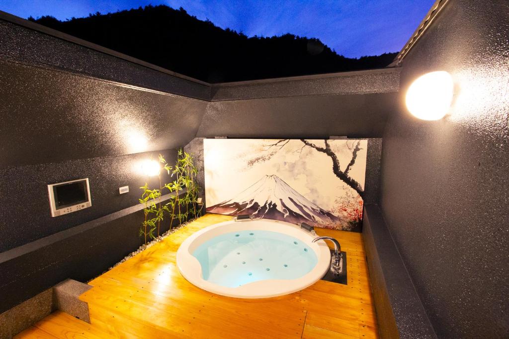 a bathroom with a tub in the middle of a room at Canon Himeji Higashi (Adult Only) in Himeji