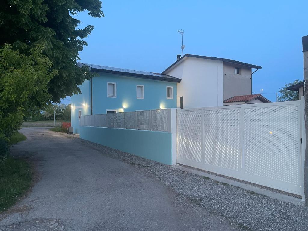 a white fence in front of a house at Ama affittacamere in Gleris