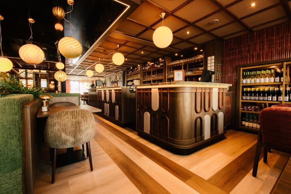 a restaurant with a bar with a wine cooler at De Herbergh van Flielant in Oost-Vlieland