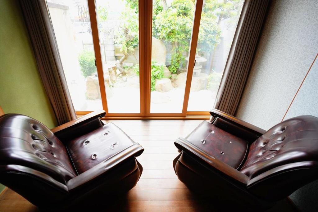 two leather chairs in a room with a window at 碧 AO Antik&Bay in Takamatsu