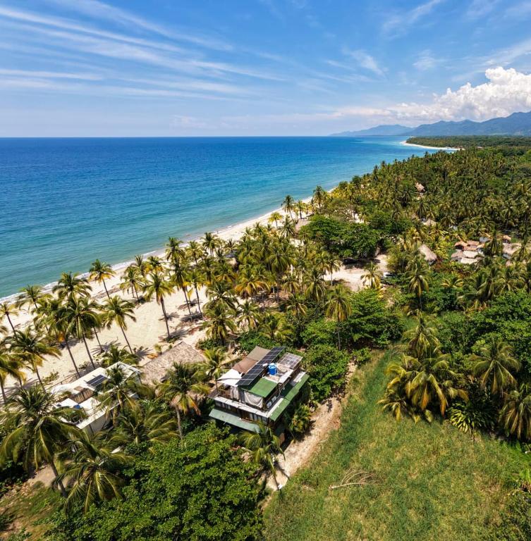 an aerial view of a resort with palm trees and the ocean at Natyva House in Guachaca