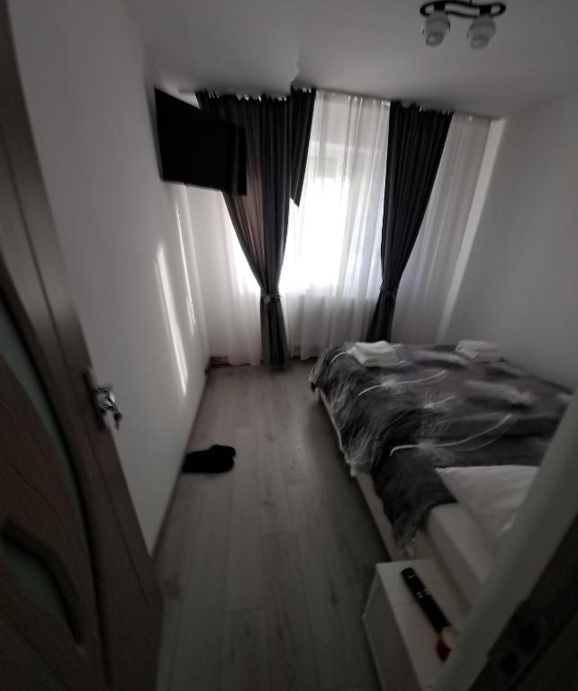 a small bedroom with a bed and a window at Montain apartament in Brezoi