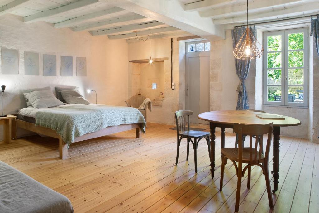 a bedroom with a bed and a table and chairs at Idyl 2020 in Migré