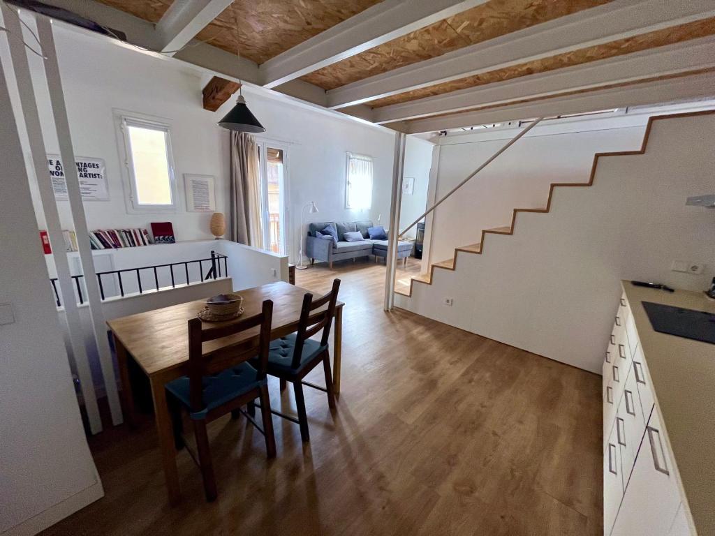 a kitchen and dining room with a table and a staircase at Casa a 20 minuts de Barcelona in Molins de Rei
