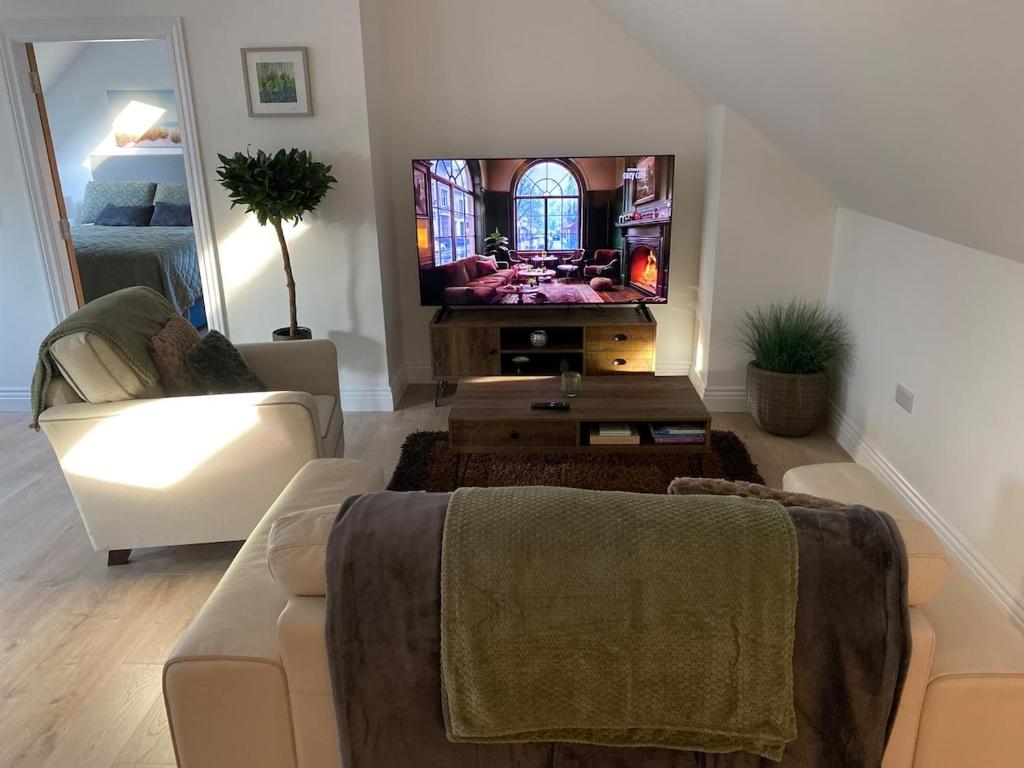 a living room with a couch and a flat screen tv at The Stables Apartment in Midleton