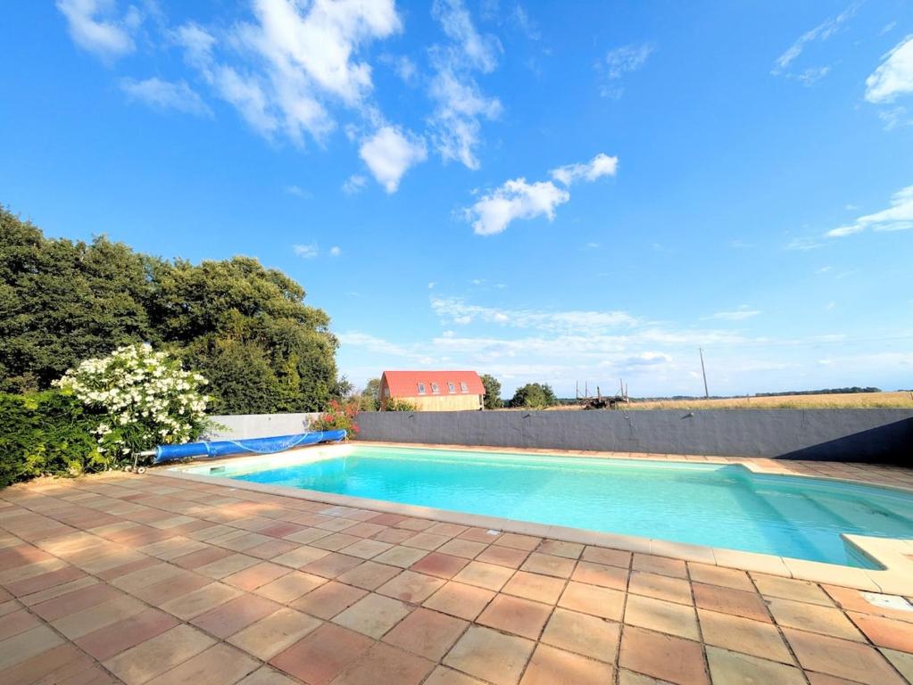 a swimming pool in a yard with a brick patio at Au Marron in Seissan
